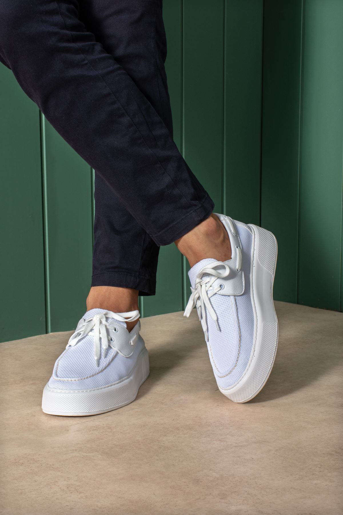 White and light blue lace-up knit sneakers, front view with white laces and sole.