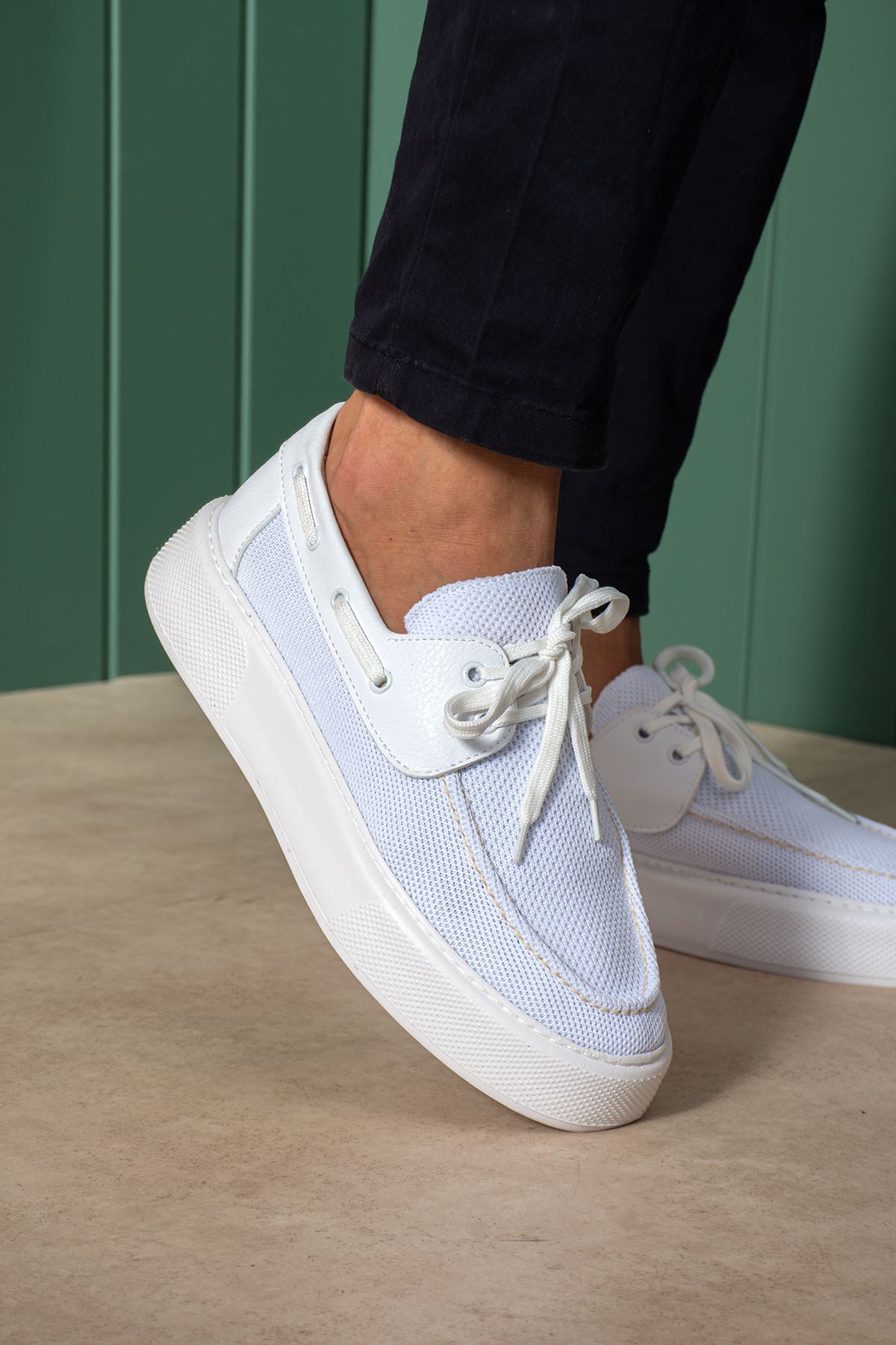 White and light blue lace-up knit sneakers, close-up side with eyelets and laces.