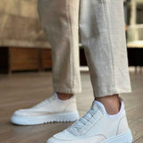 White knit sneakers with round toe and treaded rubber sole, stepping stance