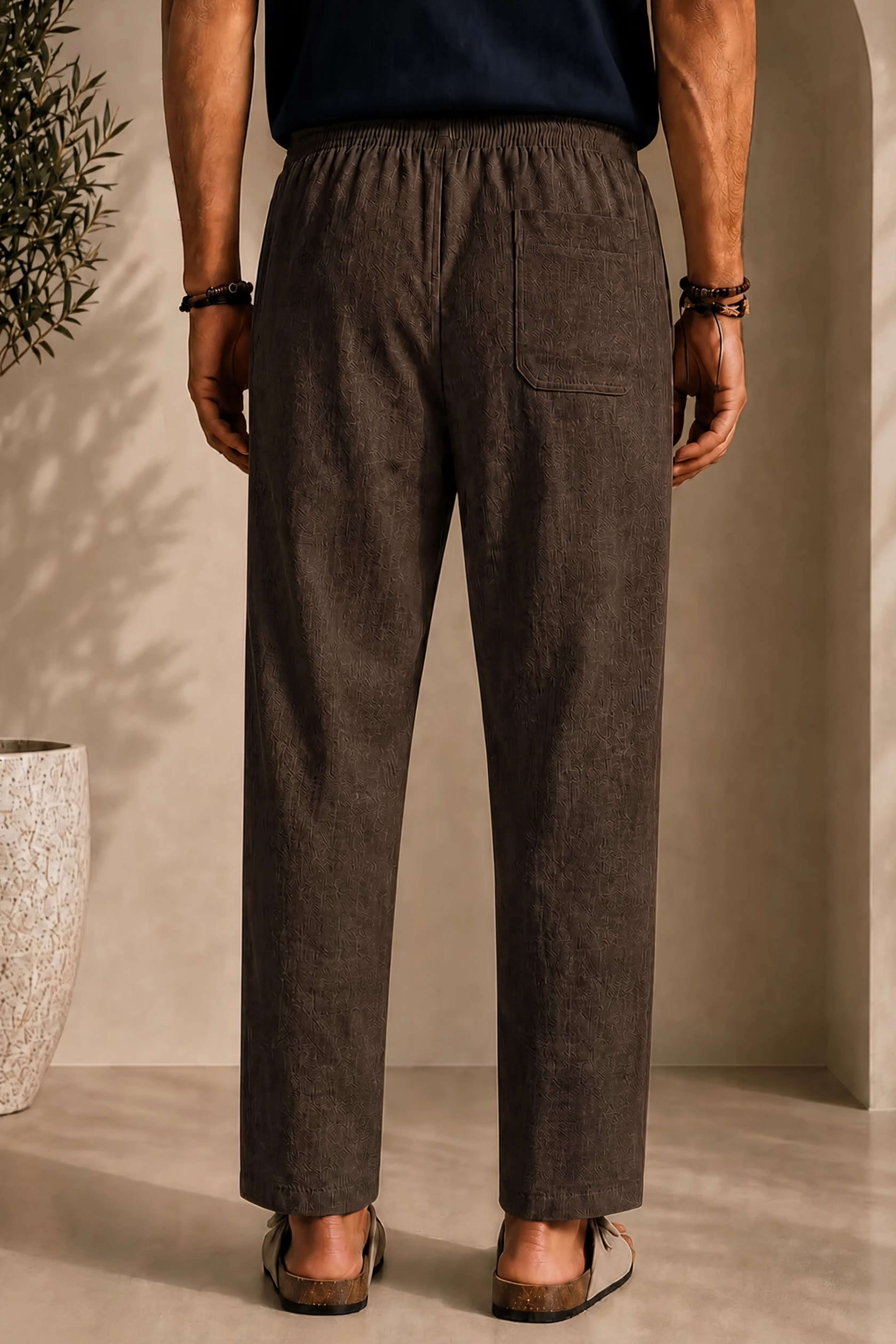 Linen pants, back view: elastic waist, center seam, side pockets, dark brown
