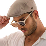 Men's mink flat cap Ritag in taupe, front side view with metal eyelet