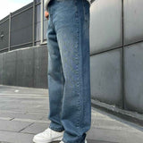 Relaxed blue denim jeans in side profile, wide legs and cuffed hems