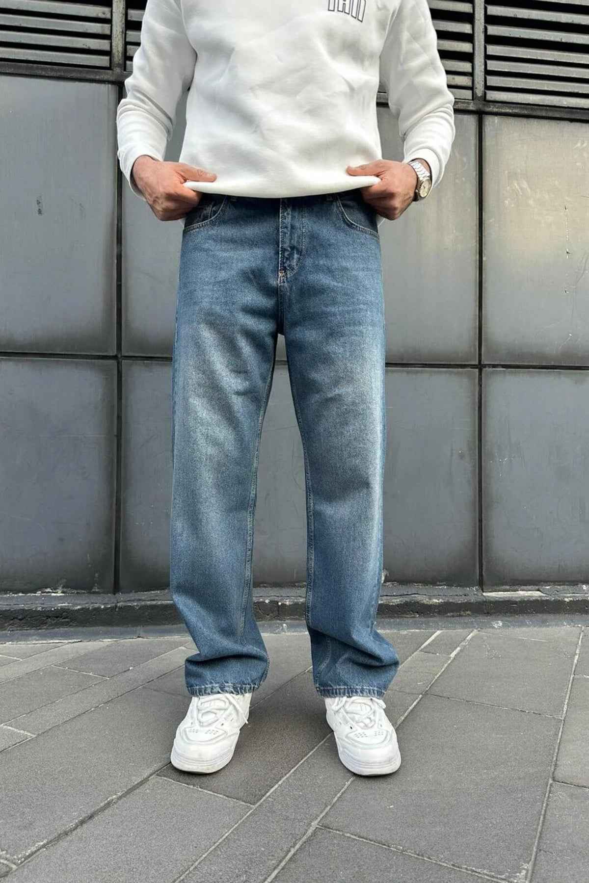 Relaxed-fit blue denim jeans front view, wide straight legs and cuffed hems