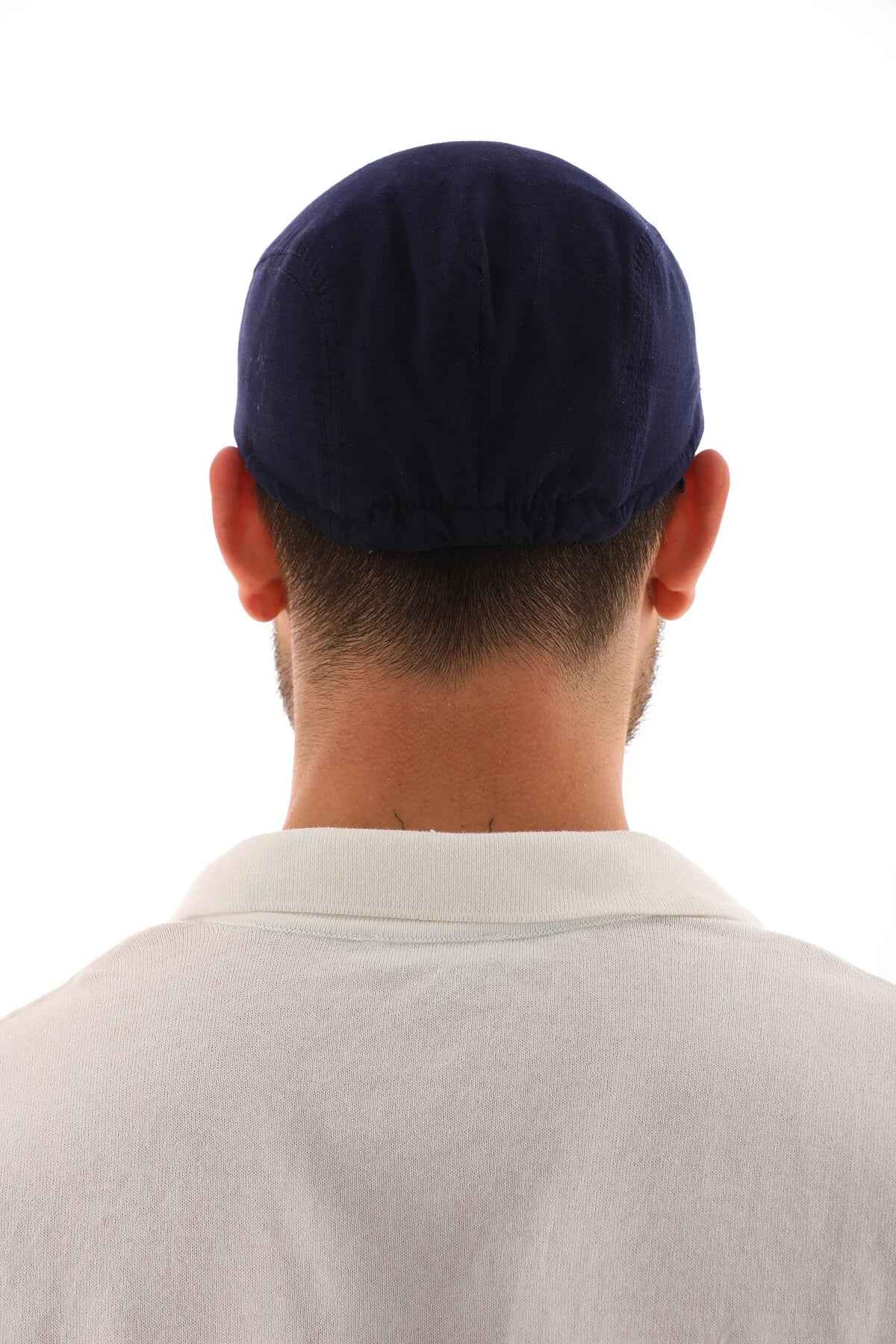Men's navy blue flat cap back view, rounded crown and curved brim