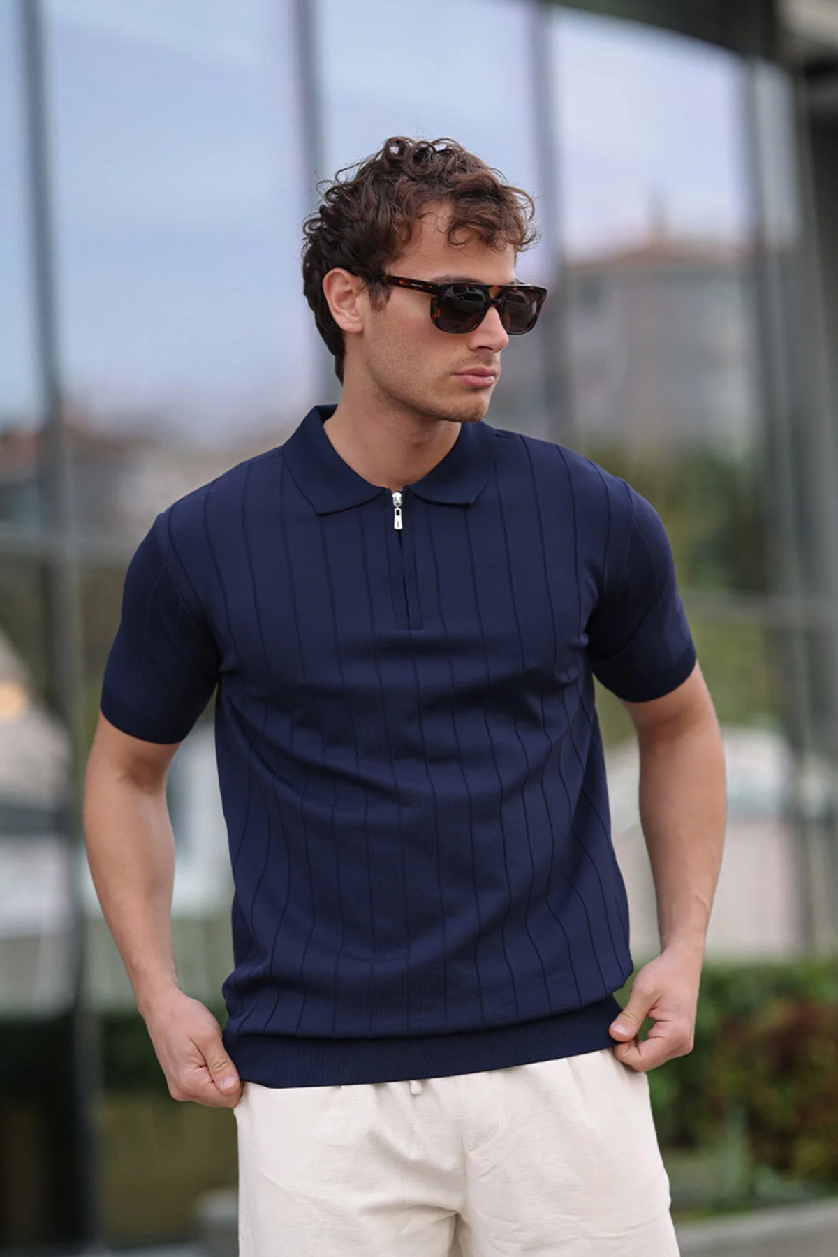 Men's navy knit half-zip polo shirt with ribbed collar and vertical stripe texture