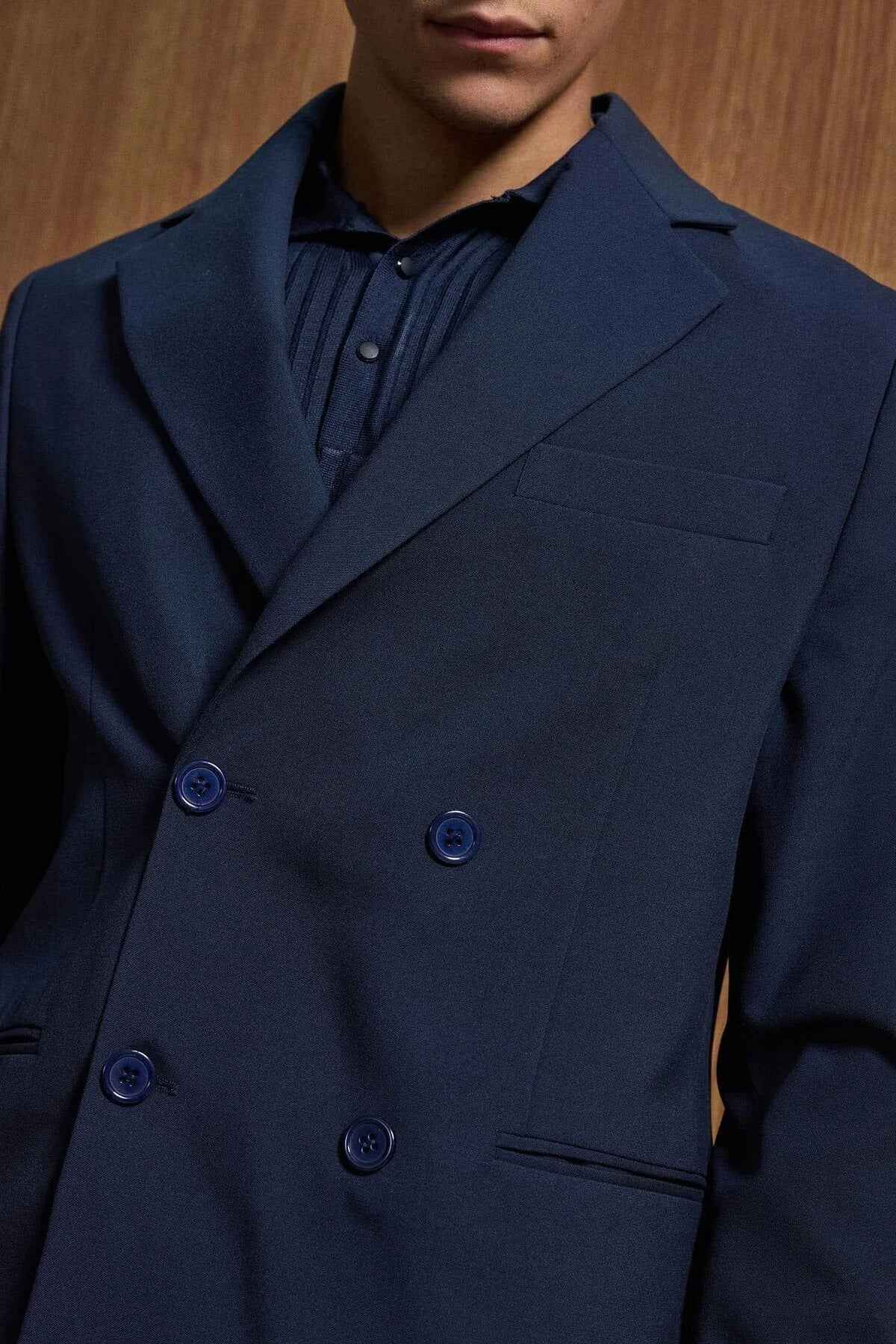 Navy double-breasted suit jacket with buttoned cuffs and chest welt pocket
