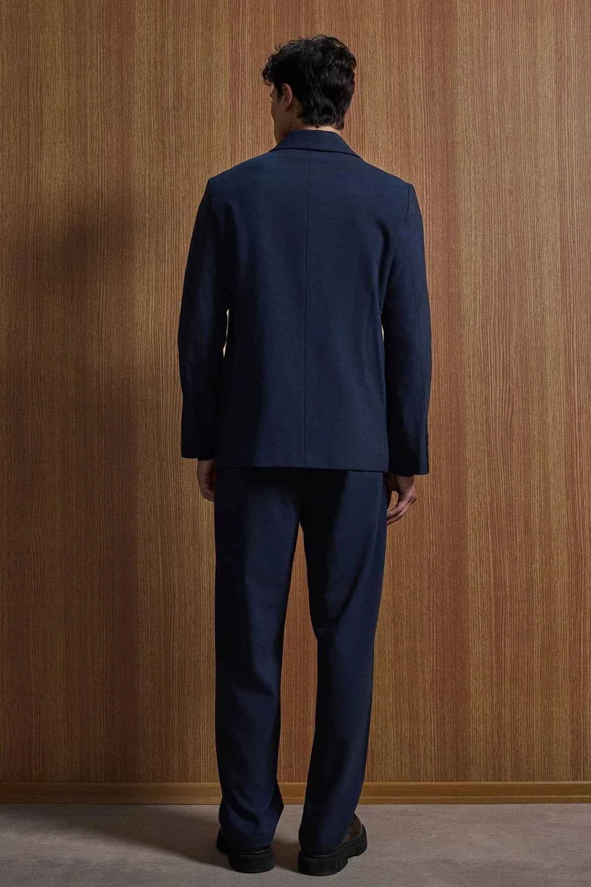 Navy suit jacket and trousers, back view