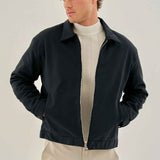 Men's dark blue zip-front jacket with stand collar, worn open at chest