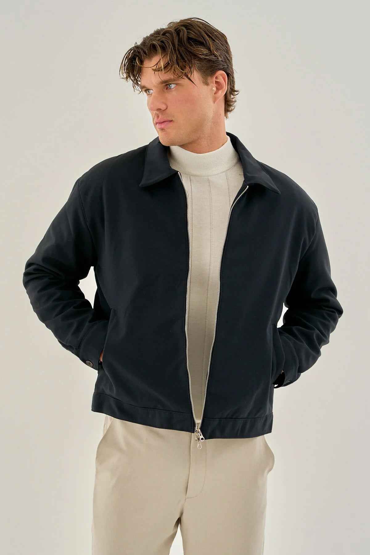 Men's dark blue zip-front jacket with stand collar, worn open at chest