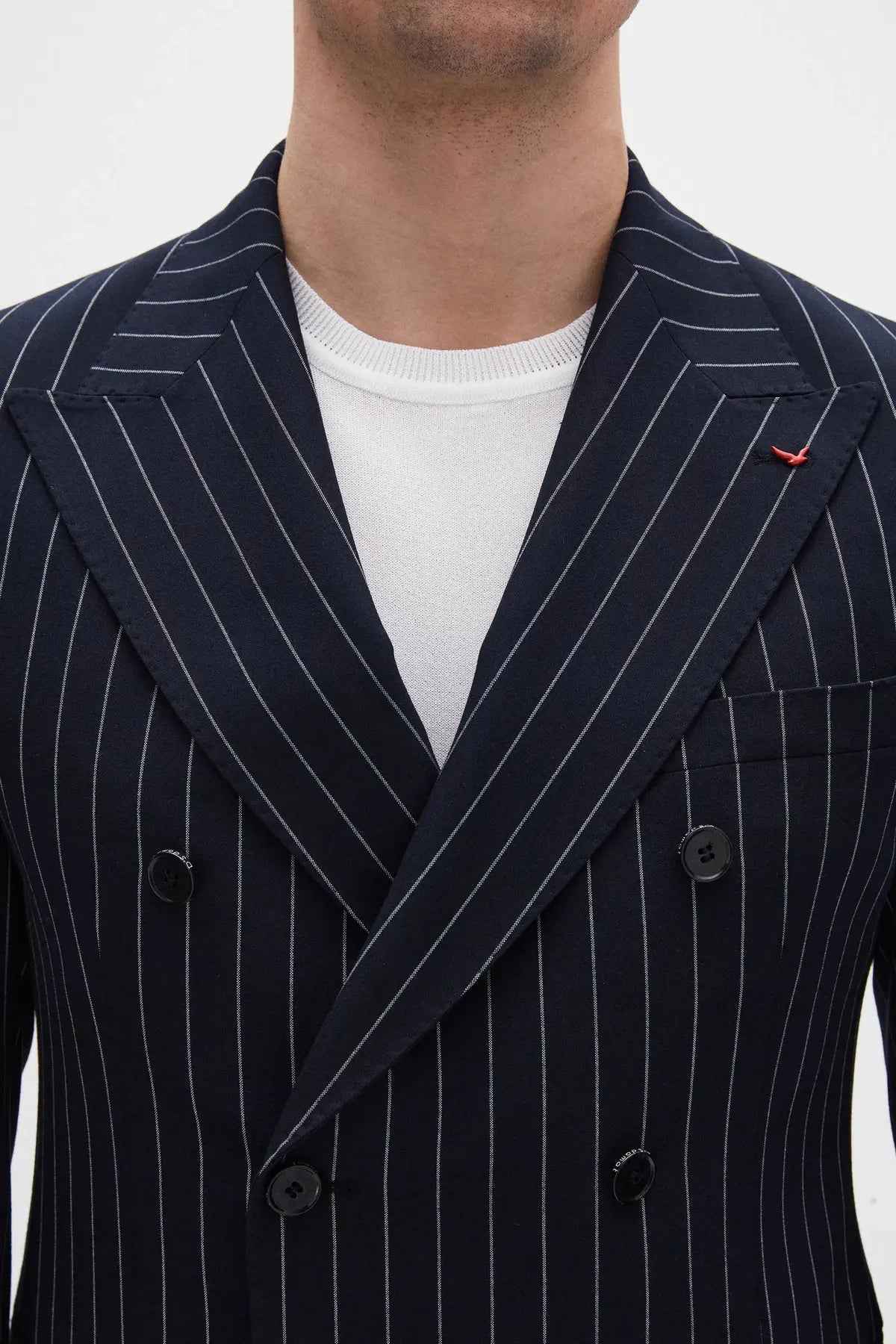 Men's navy pinstripe suit jacket lapels with double-breasted button closure