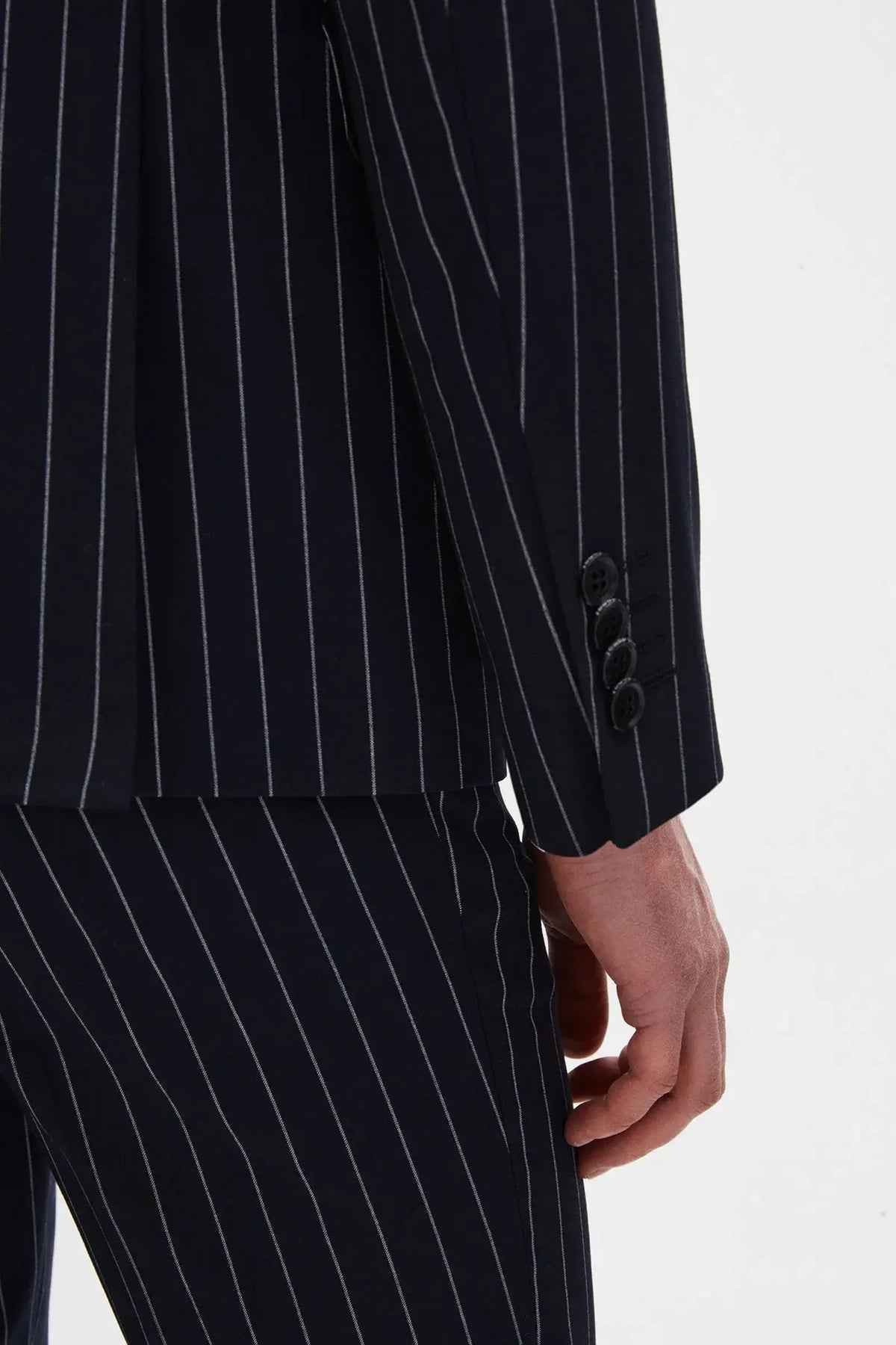Men's navy pinstripe suit jacket sleeve and matching trouser leg