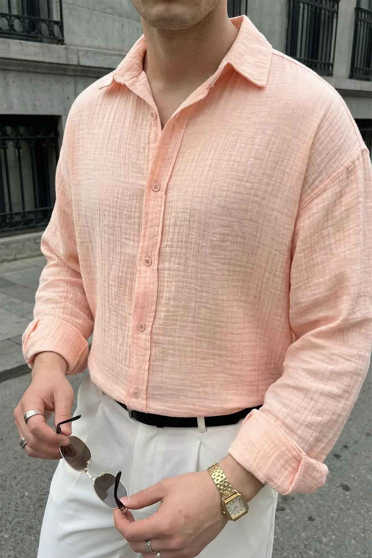 Mens pink dress shirt close-up with button placket and spread collar, long sleeves.