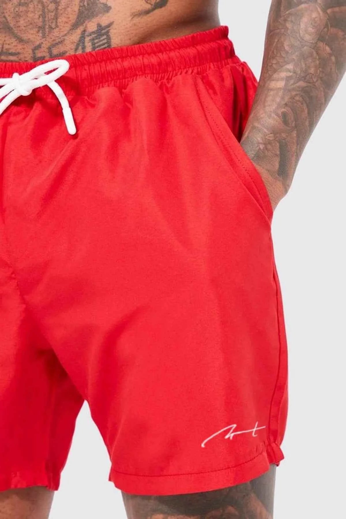 Red swim shorts with white drawstring, elastic waist, and small hem logo