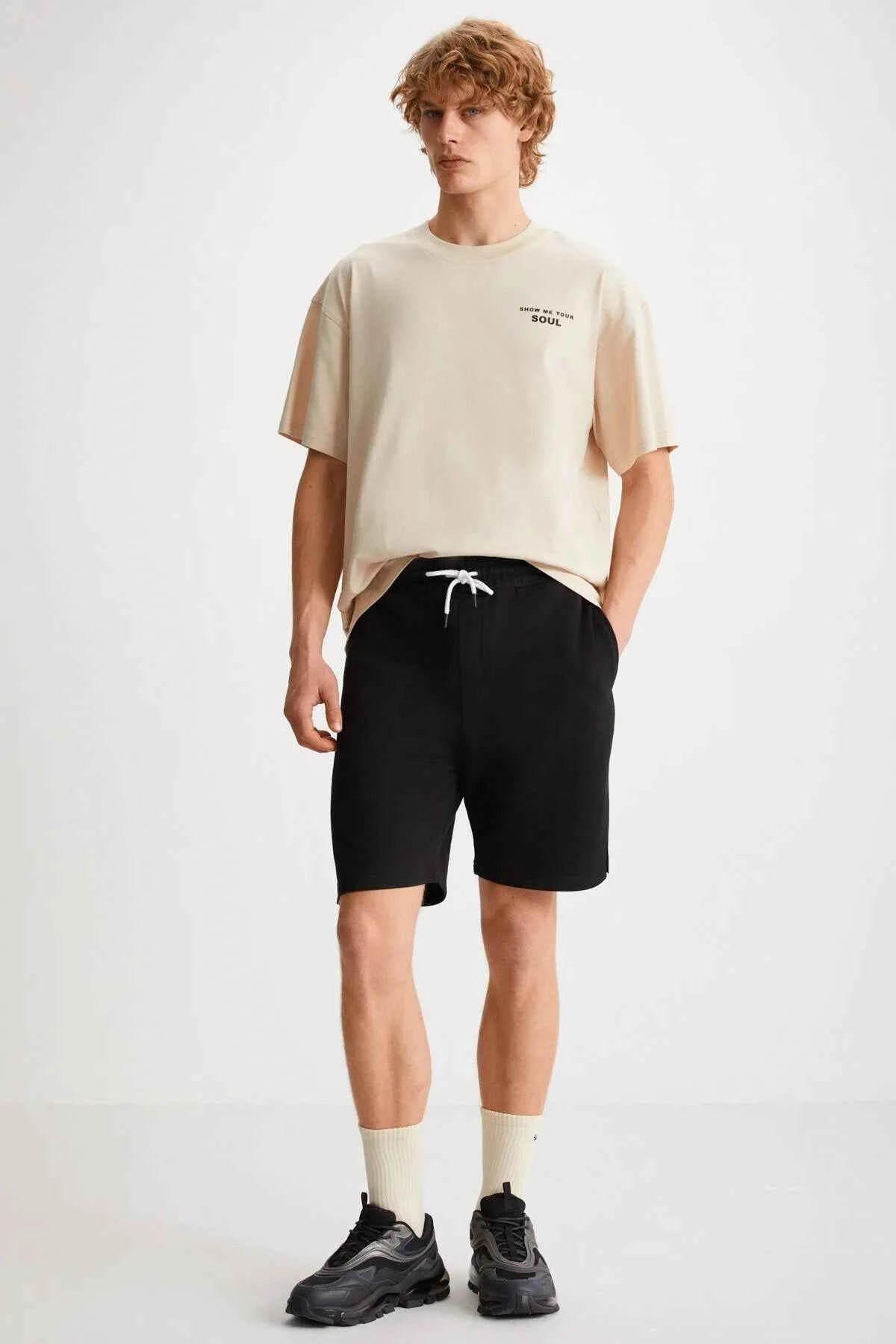 Black bermuda shorts with white drawstring, knee-length fit