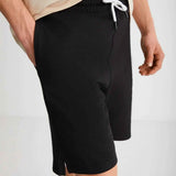 Black bermuda shorts close-up, drawstring waist and stitched seams