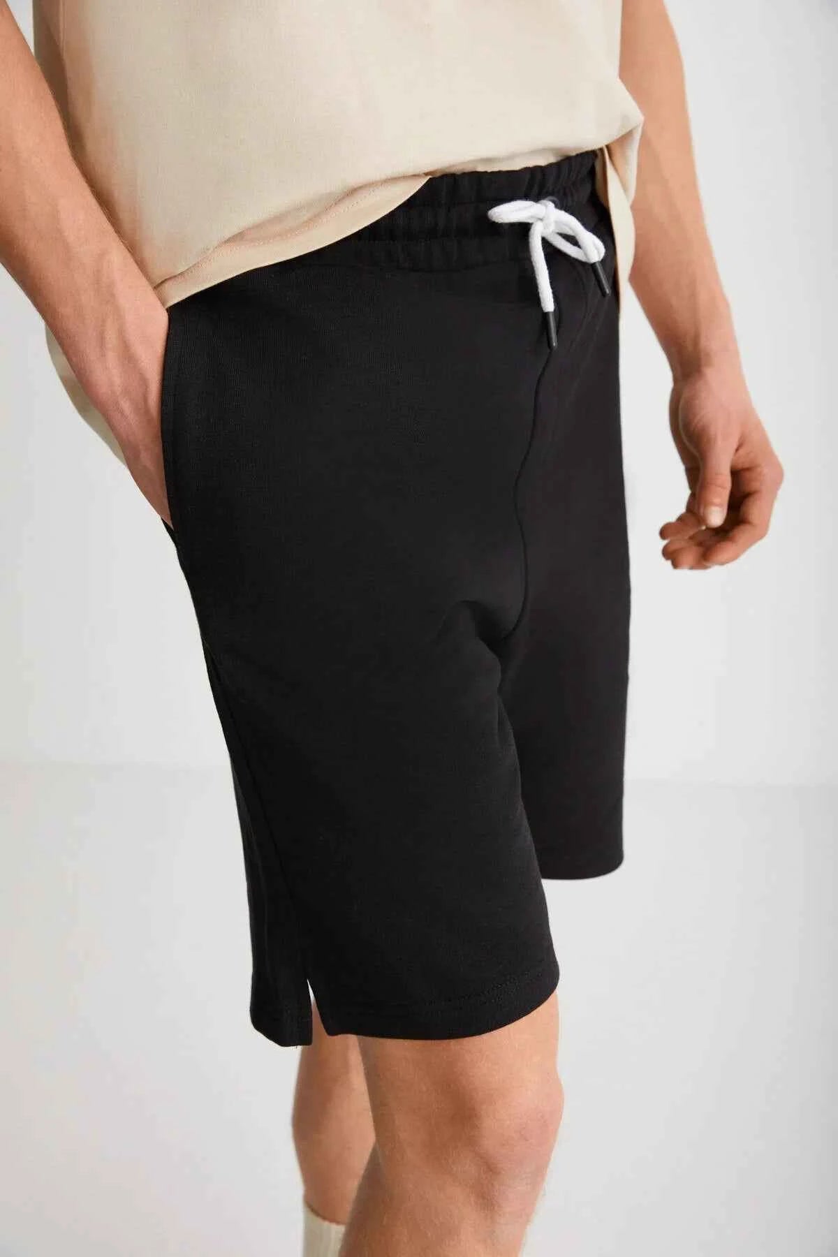 Black bermuda shorts close-up, drawstring waist and stitched seams