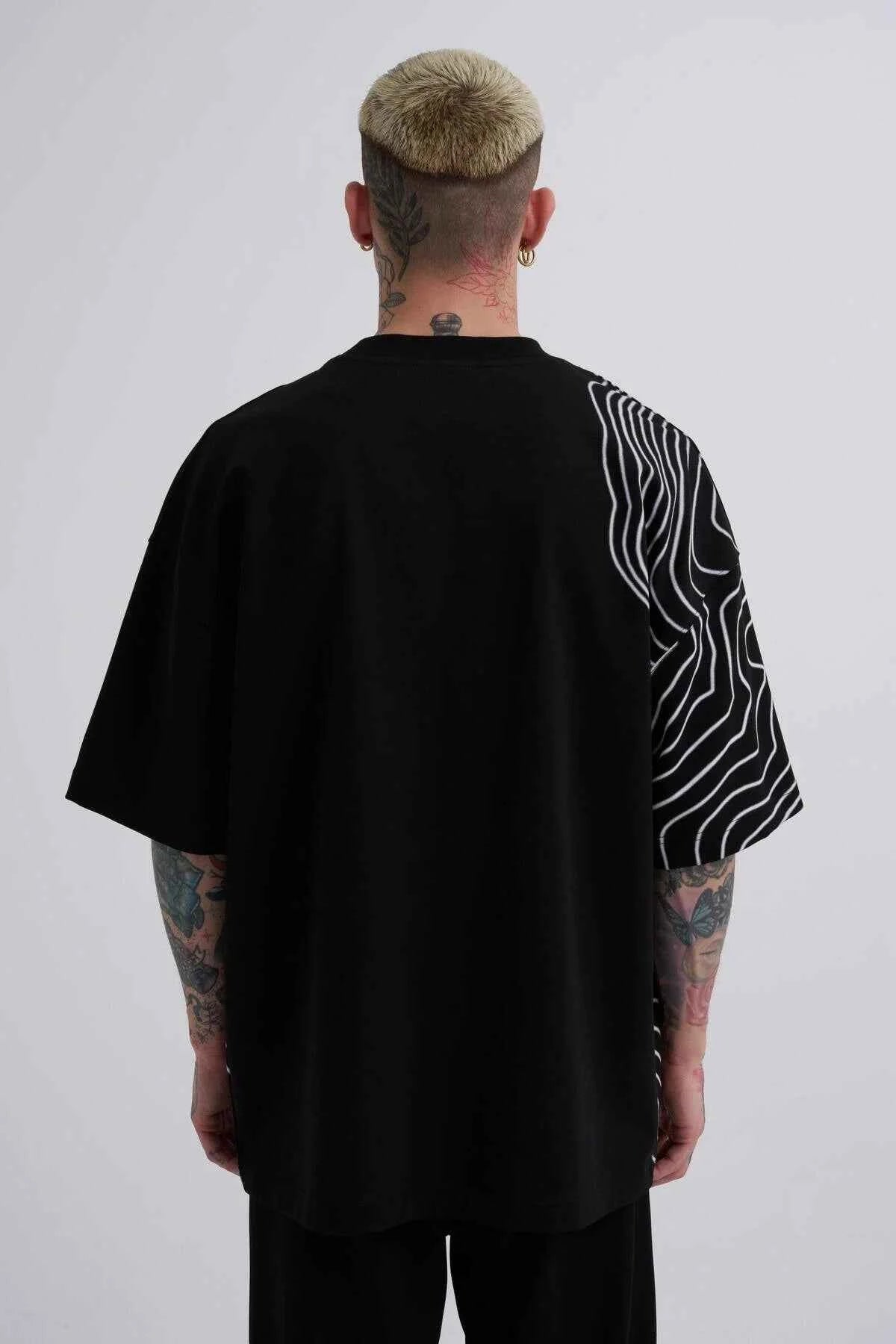 Men's oversize black T-shirt, back view, with white stripe graphics and small green Macstrar logo