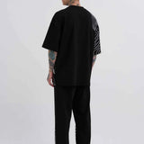 Men's oversize black T-shirt, back view, with white stripe panel graphic