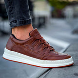 Men's tan lace-up sneakers close-up, white sole and laces