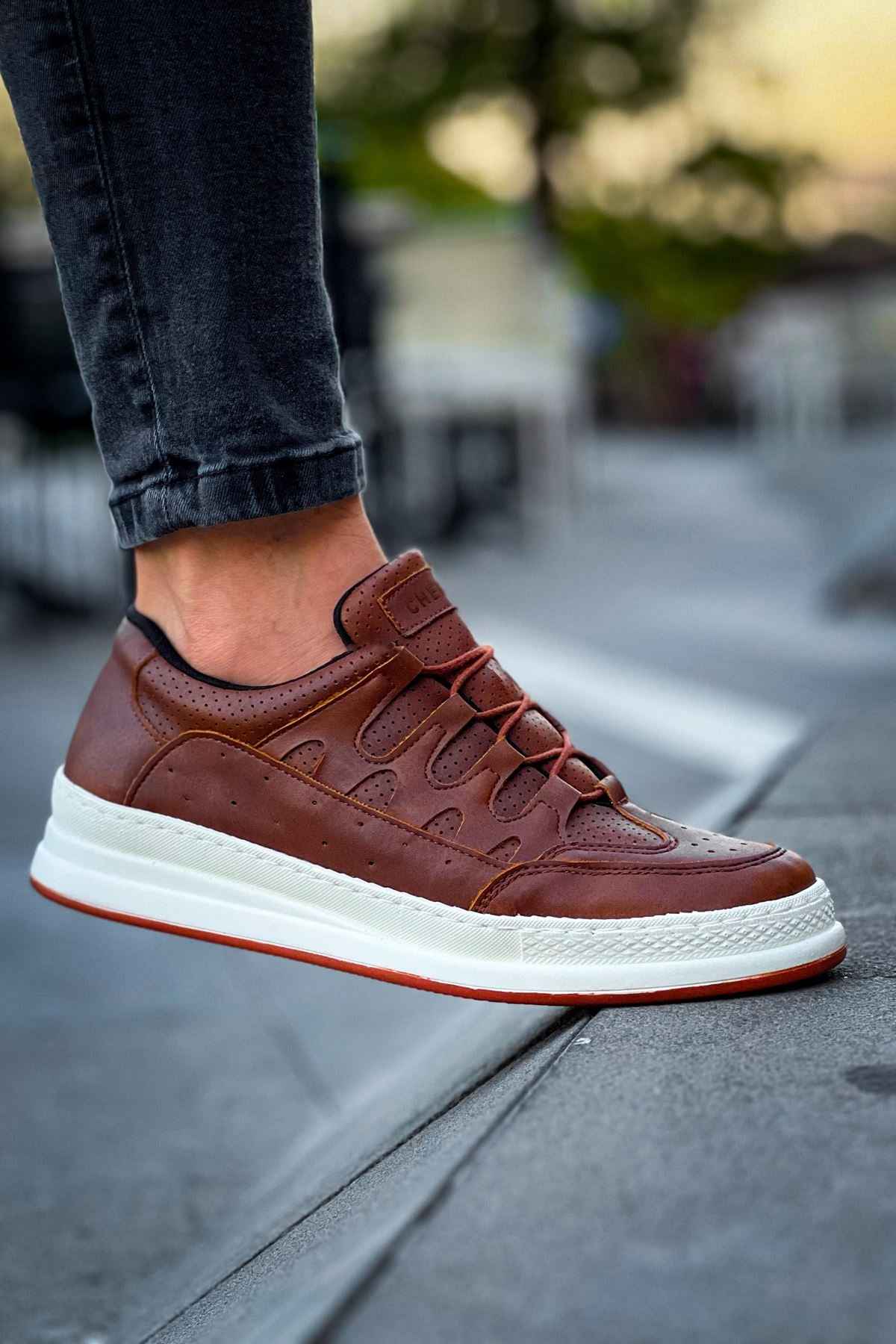 Men's tan lace-up sneakers close-up, white sole and laces
