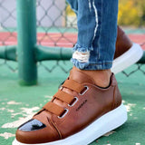 Men's tan lace-up sneakers with black logo on side, white rubber sole