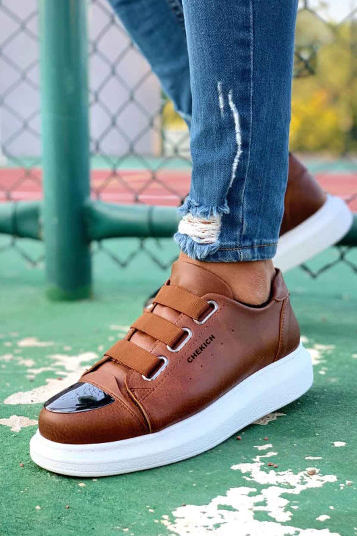 Men's tan lace-up sneakers with black logo on side, white rubber sole