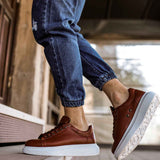 Men's tan sneakers with white sole and visible sidewall tread