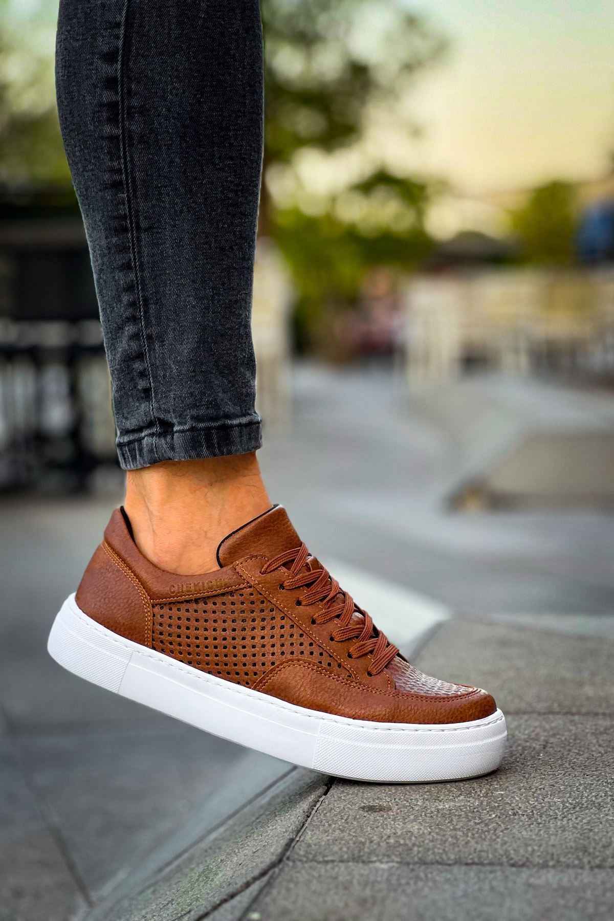 Tan Lix sneakers on footpath, low-top lace-up with perforated detail