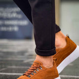 Tan suede lace-up sneakers with metal eyelets and white rubber sole