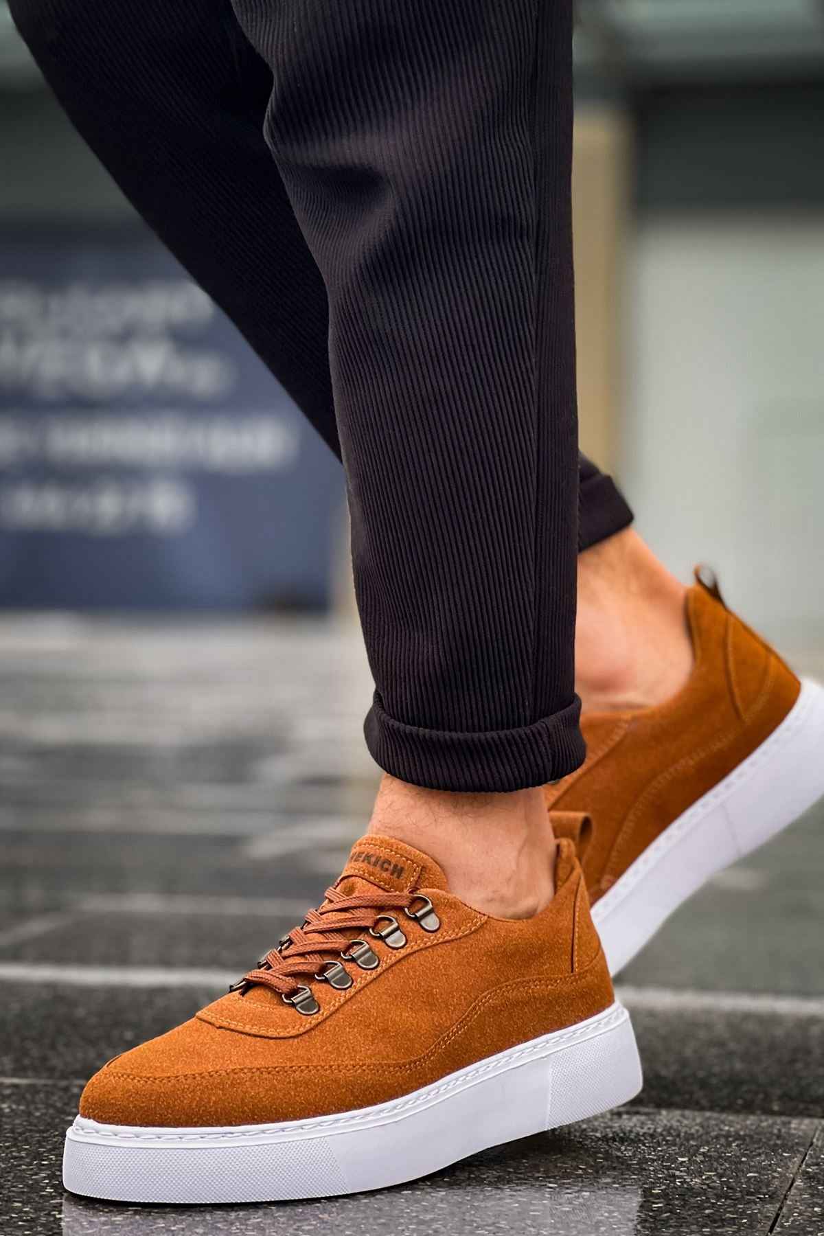 Tan suede lace-up sneakers with metal eyelets and white rubber sole