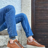 Men's tan suede sneakers with lace-up stitching and low-profile rubber sole