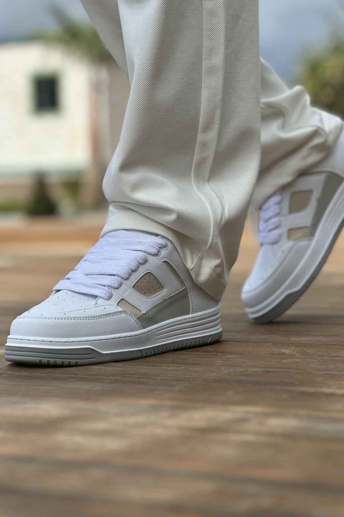 White and beige lace-up low-top sneakers, side view with gray rubber sole