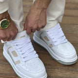 White and beige lace-up sneakers, pair worn with white pants, close front view