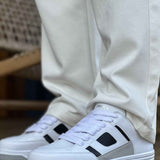 Men's white sneakers with black side panels and lace-up front