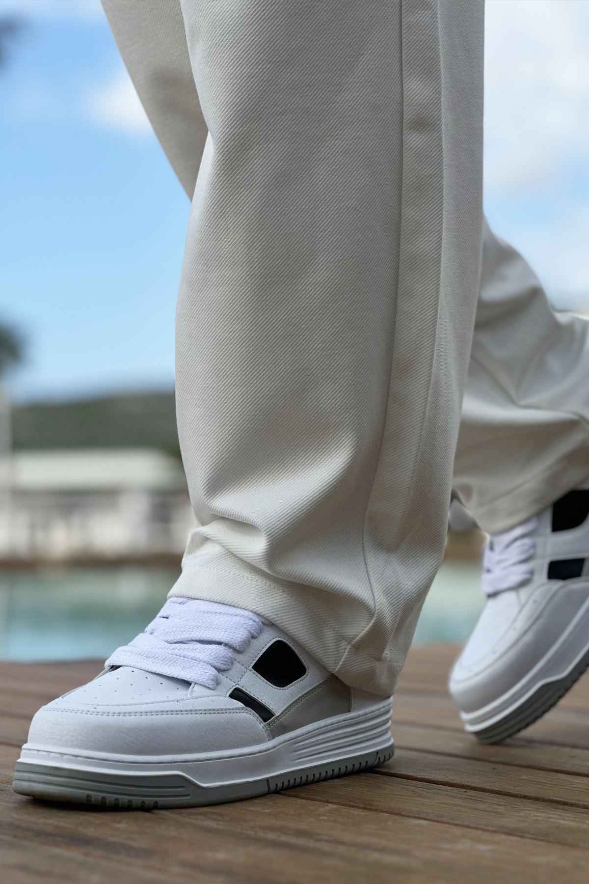 Men's white sneakers with black side strap and lace-up design