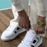 Men's white sneakers with black side patches and thick gray rubber sole