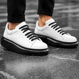 Men's white sneakers with black rubber sole, black laces, and low-top design