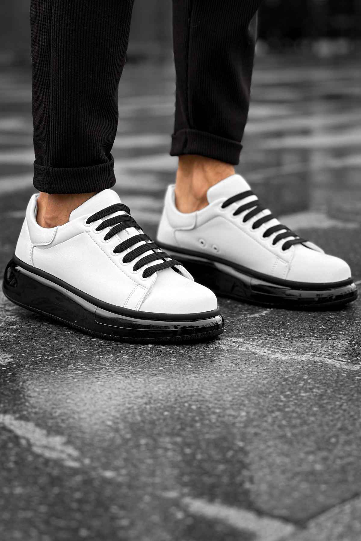 Men's white sneakers with black rubber sole, black laces, and low-top design