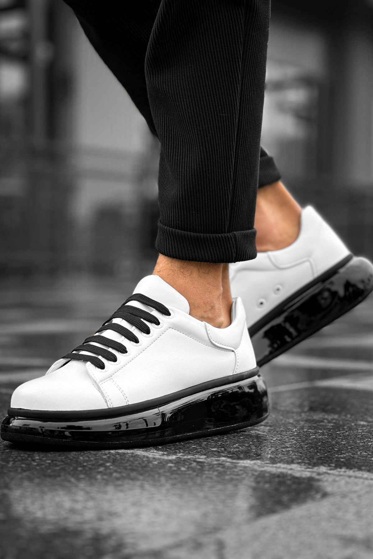 Low-top white sneakers with black lace-up front and thick black outsole