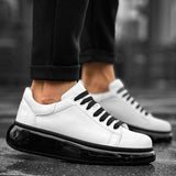 White low-top sneakers with black lace-up panel and glossy black sole edge