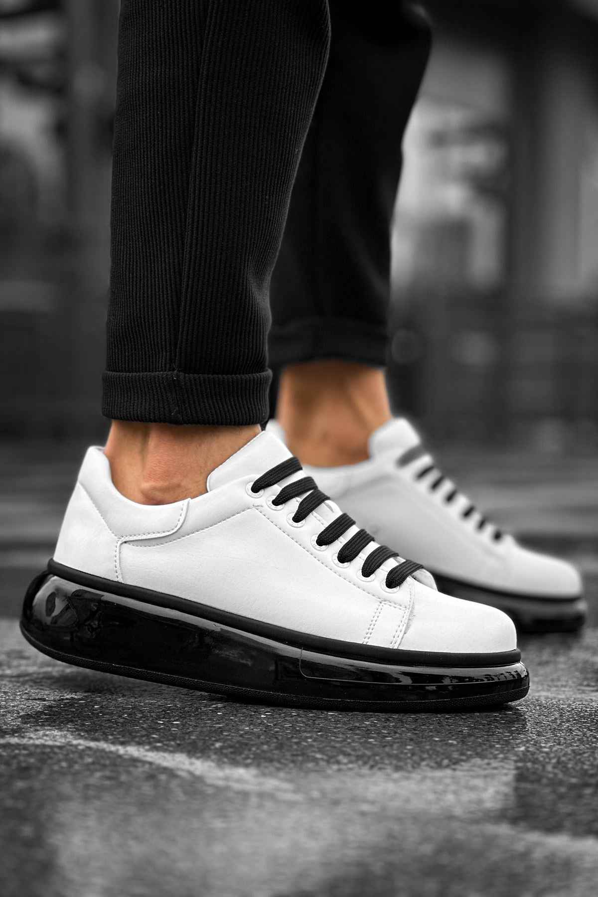 White low-top sneakers with black lace-up panel and glossy black sole edge