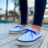 Pair of men's white espadrilles with blue lace-up and jute midsole detail