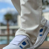 Men's white sneakers with blue side tabs and lace-up front