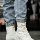 White high-top lace-up boots with metal eyelets and chunky tread sole