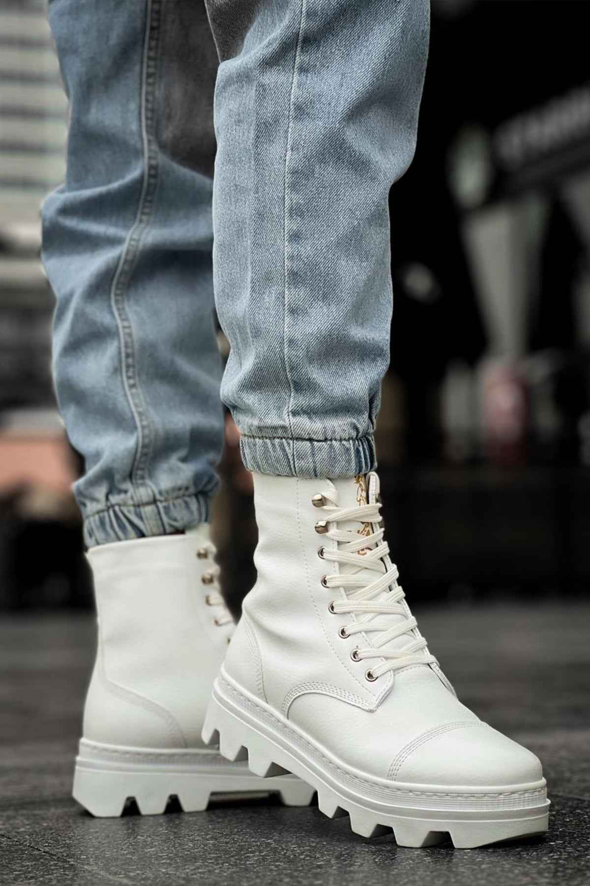 White high-top lace-up boots with metal eyelets and chunky tread sole