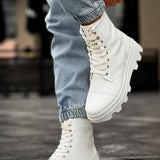White lace-up boots in side view, chunky rubber tread and stitched panels