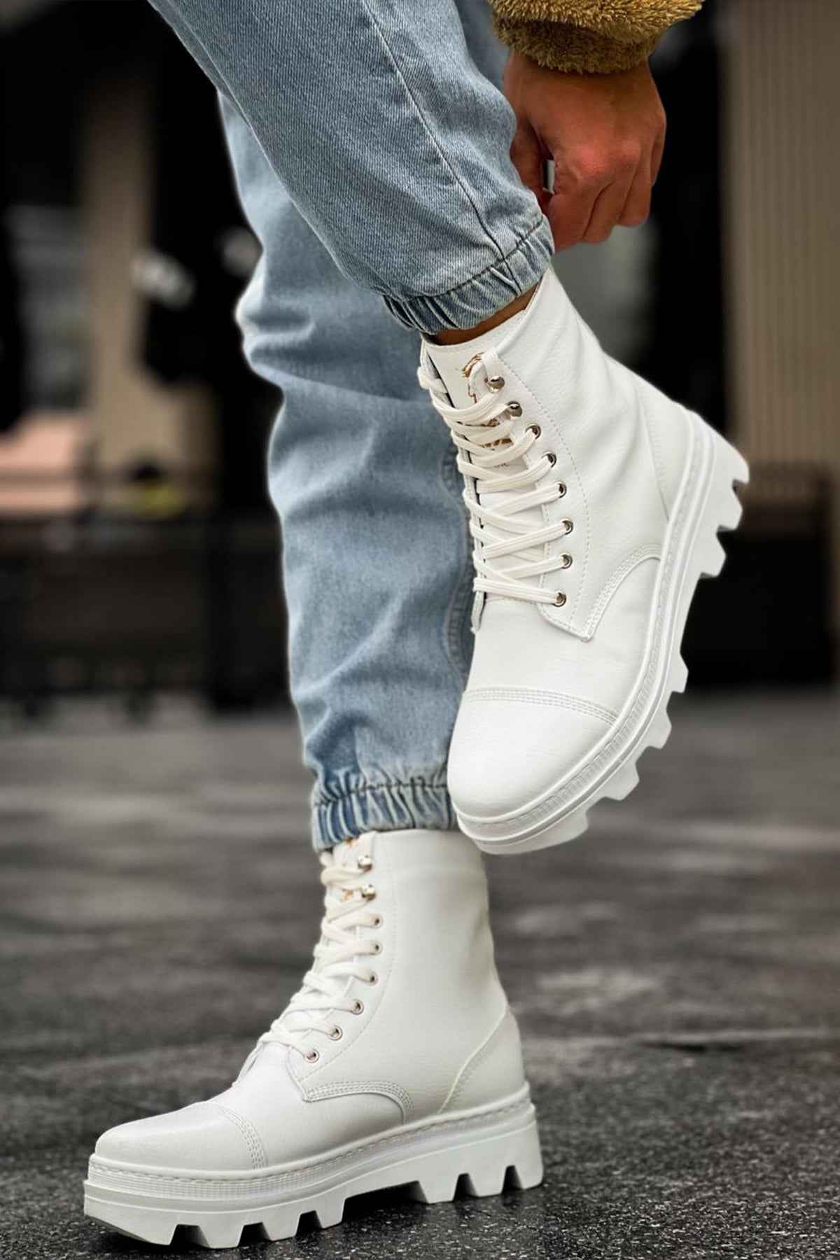 White lace-up boots in side view, chunky rubber tread and stitched panels