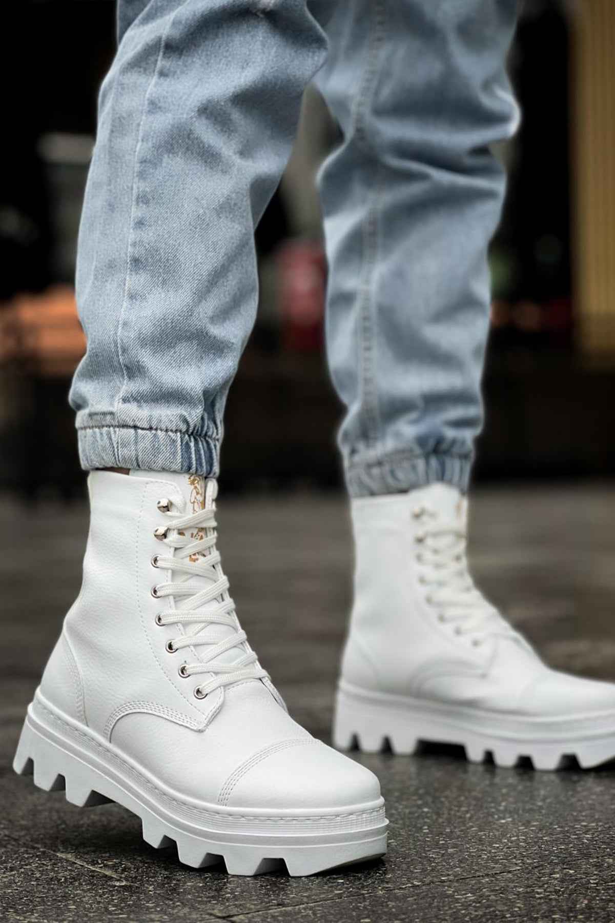 White lace-up high boots with padded collar and lug sole, front view