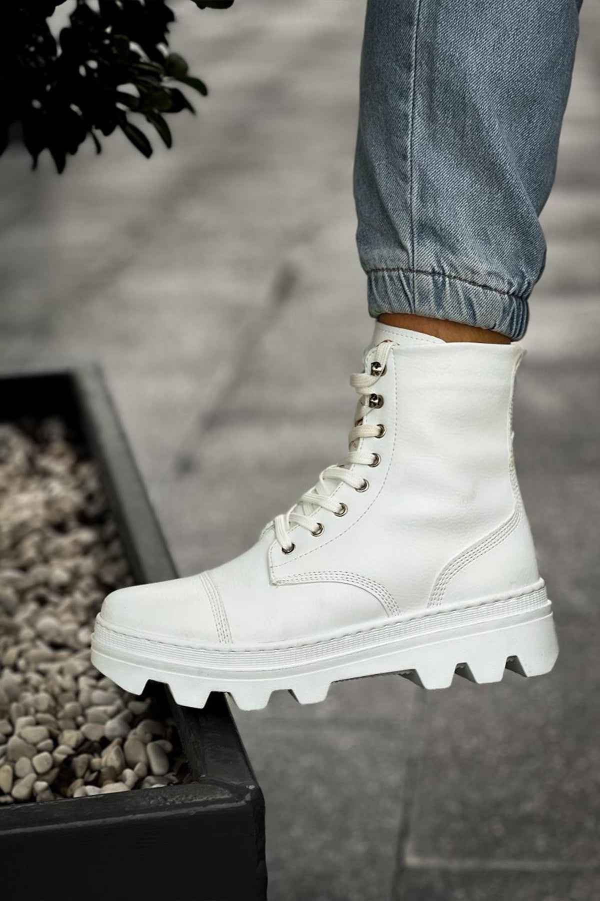 White lace-up ankle boots with eyelet hardware and rugged tread sole