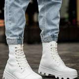 White lace-up boots with chunky tread sole and seam details, standing view